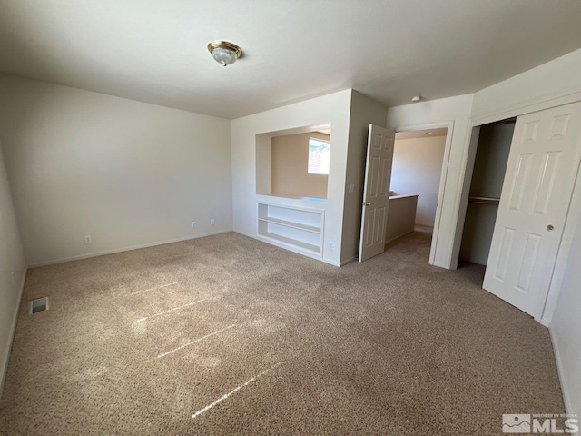 unfurnished bedroom featuring baseboards, carpet flooring, visible vents, and a closet
