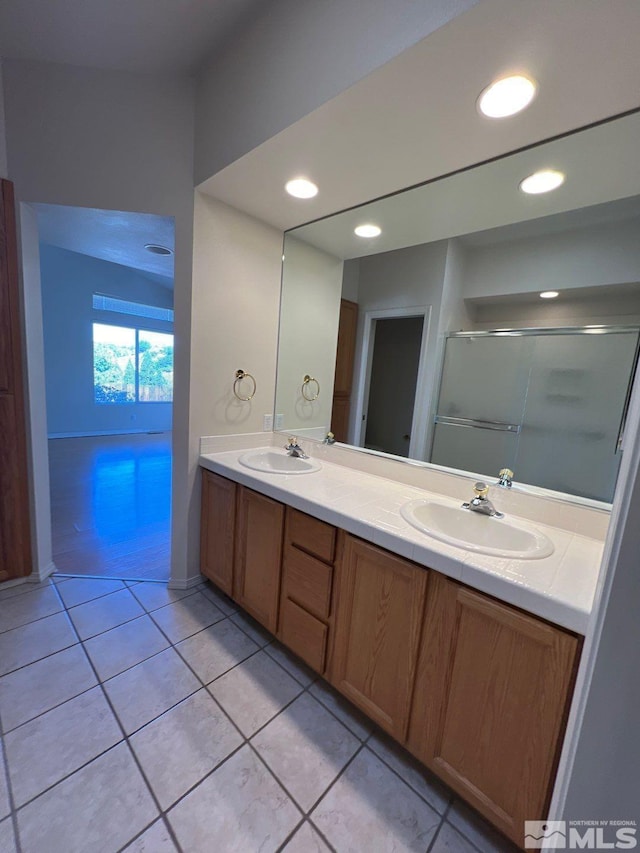 full bathroom with tile patterned floors, a sink, a shower stall, and double vanity