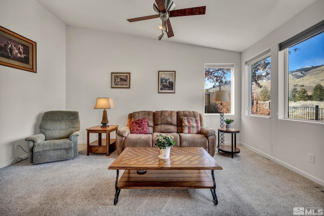 carpeted living room with ceiling fan and vaulted ceiling