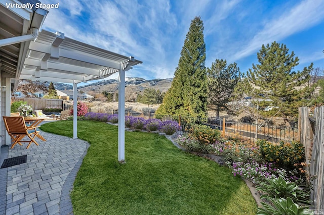 view of yard featuring a mountain view, a pergola, and a patio