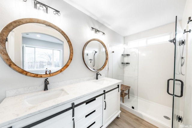 bathroom featuring hardwood / wood-style flooring, vanity, a healthy amount of sunlight, and walk in shower