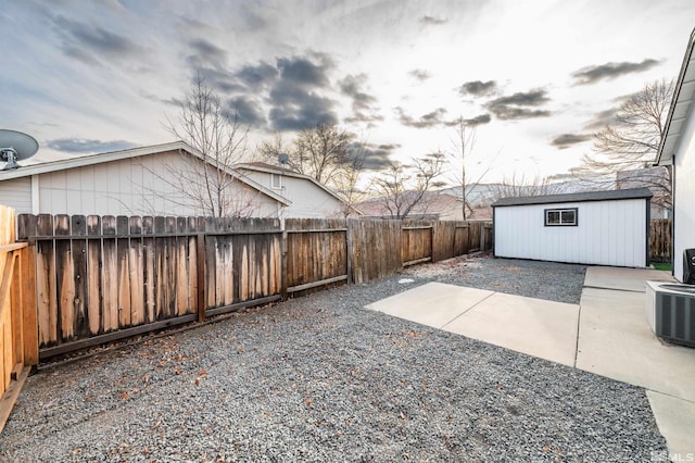 patio terrace at dusk featuring a shed