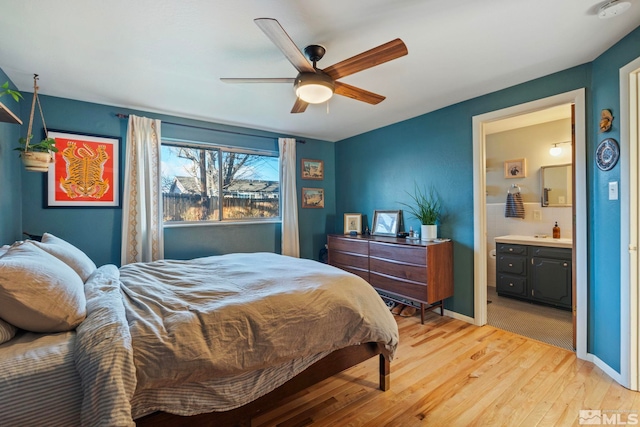 bedroom with ceiling fan, connected bathroom, and light hardwood / wood-style floors