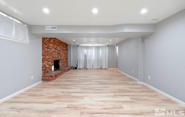 unfurnished living room with a fireplace and light hardwood / wood-style floors