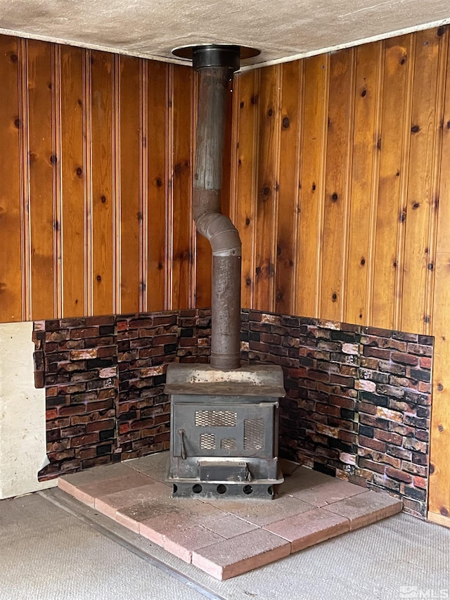 details with carpet, wood walls, a textured ceiling, and a wood stove