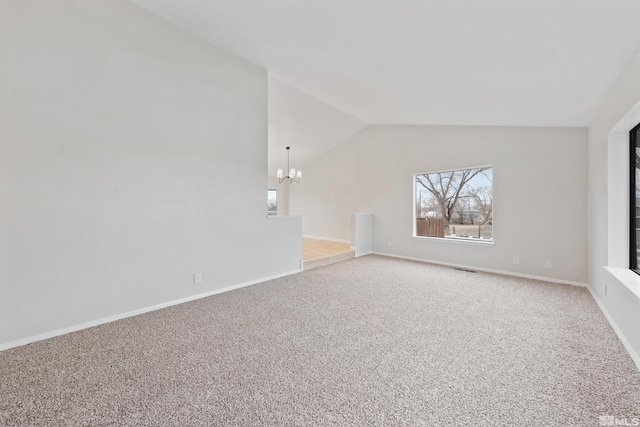 carpeted spare room featuring vaulted ceiling and a notable chandelier