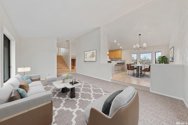 living room with an inviting chandelier, vaulted ceiling, and light carpet