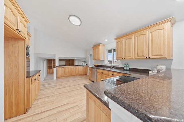 kitchen featuring vaulted ceiling, light brown cabinetry, sink, light hardwood / wood-style floors, and stainless steel appliances