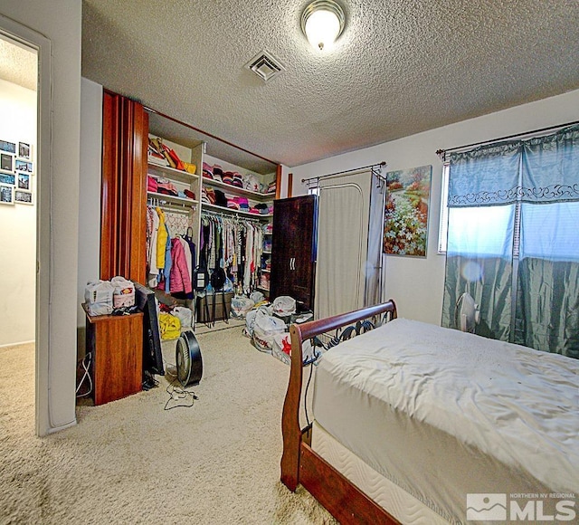 bedroom with a closet, a textured ceiling, and carpet