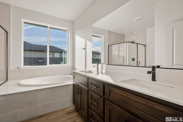 bathroom featuring hardwood / wood-style flooring, vanity, and shower with separate bathtub