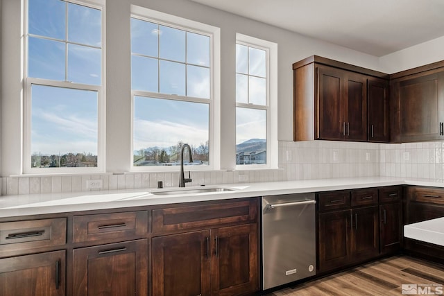 kitchen featuring decorative backsplash, sink, dark brown cabinets, and a wealth of natural light