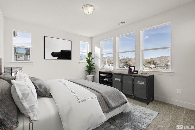 bedroom featuring a mountain view, carpet, and multiple windows