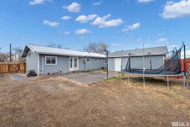 rear view of house featuring french doors, a trampoline, and a patio area