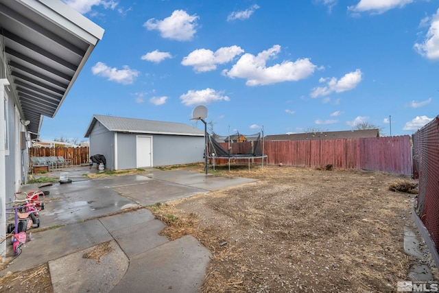 view of yard with an outbuilding, a patio area, and a trampoline