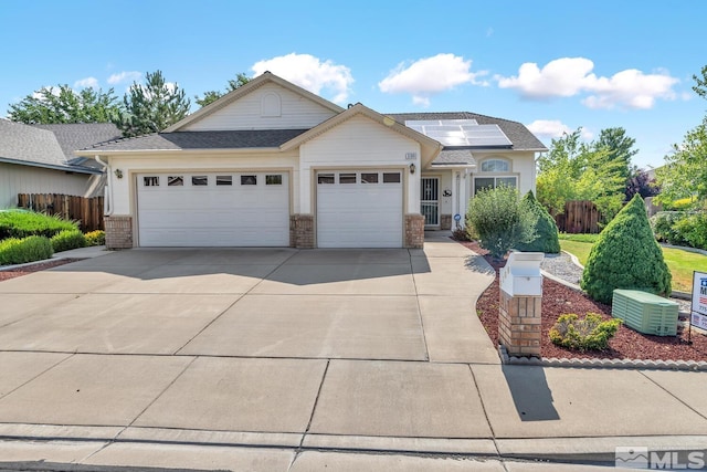 view of front of property with a garage, central AC, and solar panels