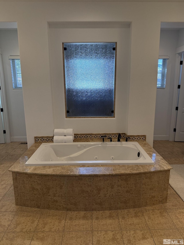 bathroom featuring tile patterned floors, plenty of natural light, and tiled bath