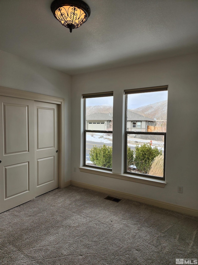 unfurnished bedroom featuring a closet, a textured ceiling, and carpet flooring