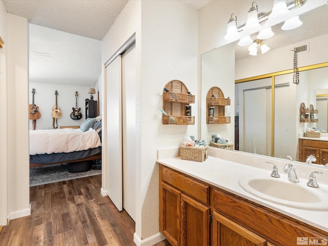 bathroom featuring vanity, wood-type flooring, and a textured ceiling