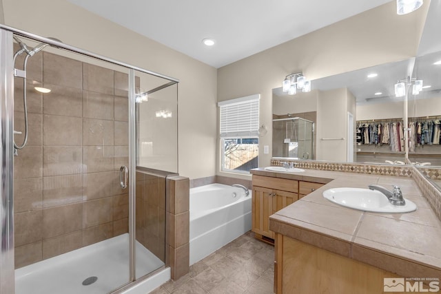 bathroom with vanity, tile patterned flooring, and plus walk in shower