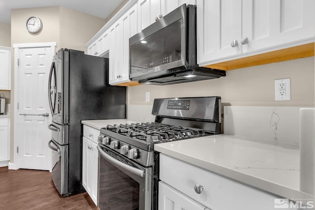 kitchen featuring dark wood-type flooring, white cabinets, light stone counters, and stainless steel gas stove