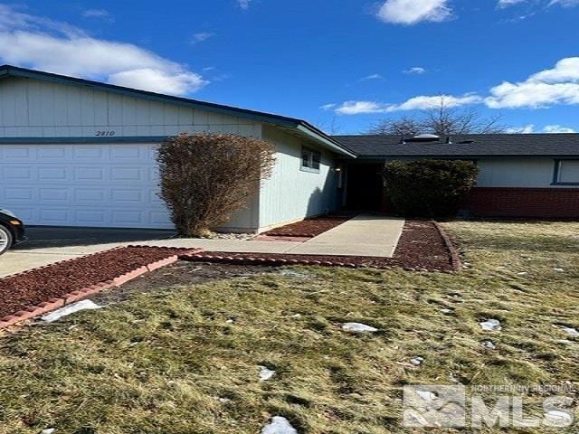 view of side of home with a garage and a lawn