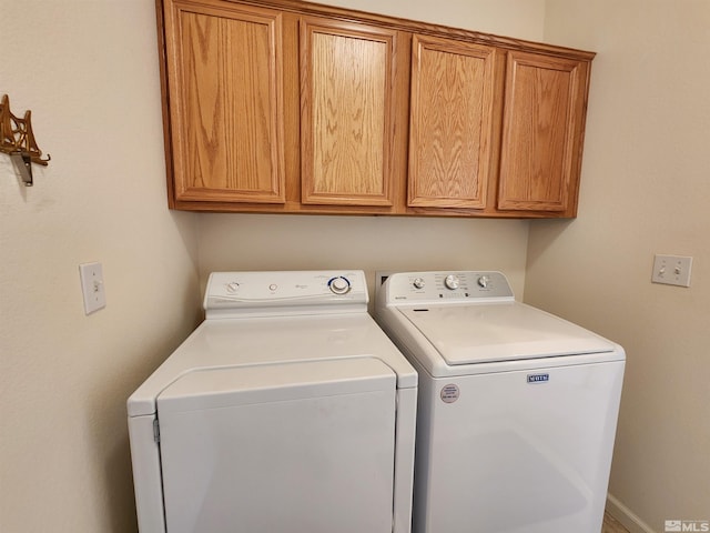 laundry area with cabinets and washing machine and clothes dryer