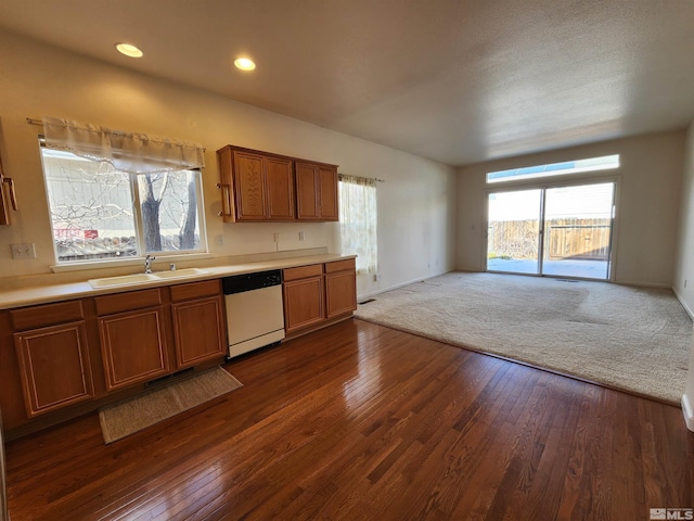 kitchen featuring a healthy amount of sunlight, dark hardwood / wood-style flooring, dishwasher, and sink