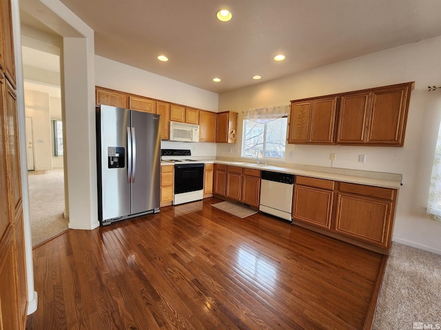 kitchen featuring appliances with stainless steel finishes, dark wood-type flooring, and sink