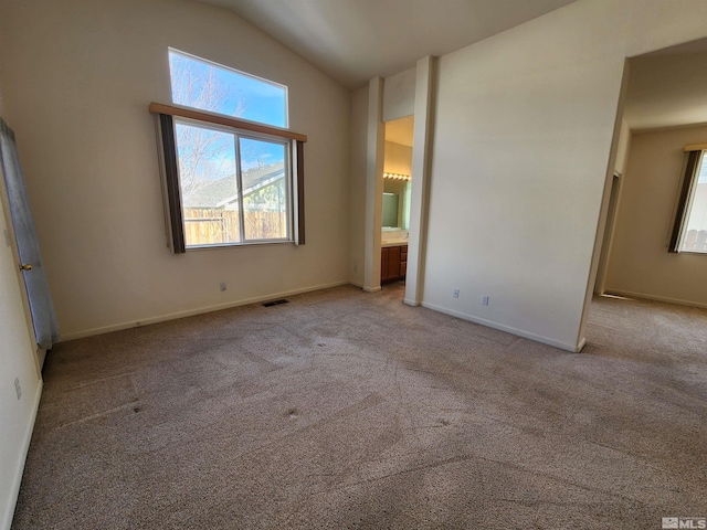 unfurnished bedroom featuring lofted ceiling and light carpet