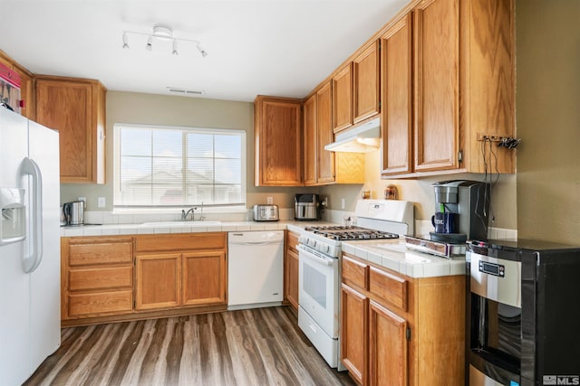 kitchen featuring white appliances, tile countertops, dark hardwood / wood-style flooring, and sink