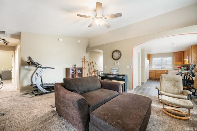 living room with vaulted ceiling, ceiling fan, and sink