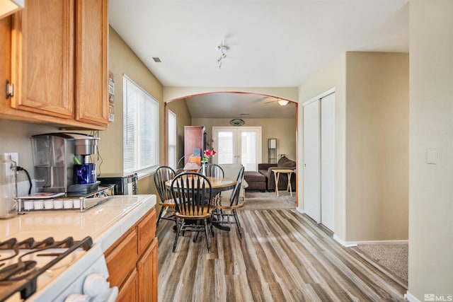 kitchen with french doors, tile counters, and light wood-type flooring