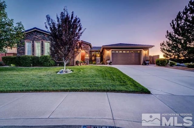 view of front of property with a garage and a lawn