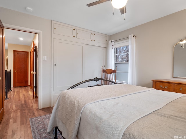 bedroom featuring hardwood / wood-style floors, ceiling fan, and a closet