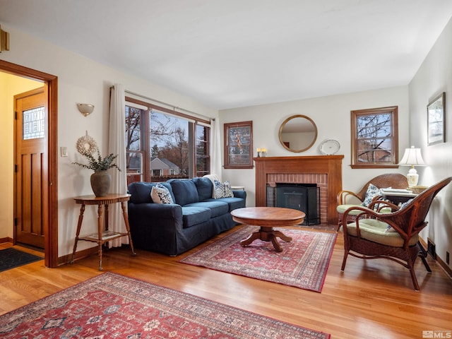 living room featuring a brick fireplace and hardwood / wood-style flooring