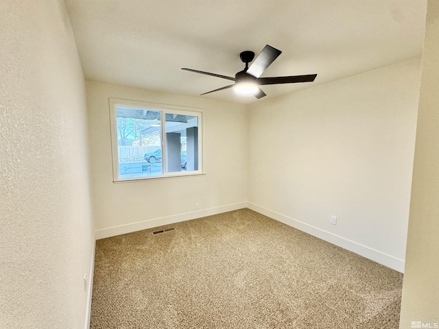 carpeted spare room with ceiling fan