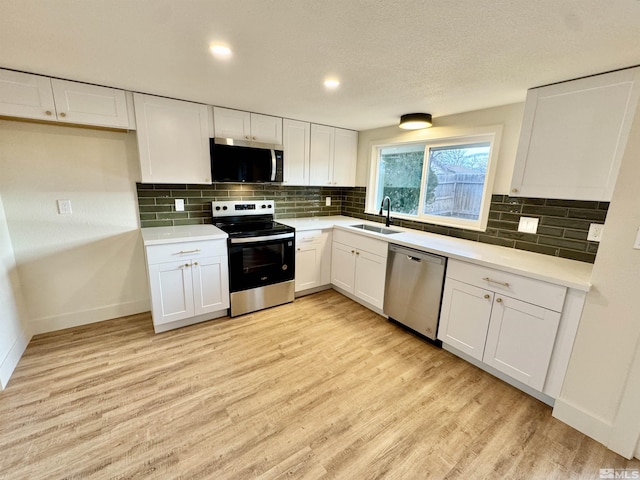 kitchen with stainless steel appliances, light hardwood / wood-style floors, sink, and white cabinets