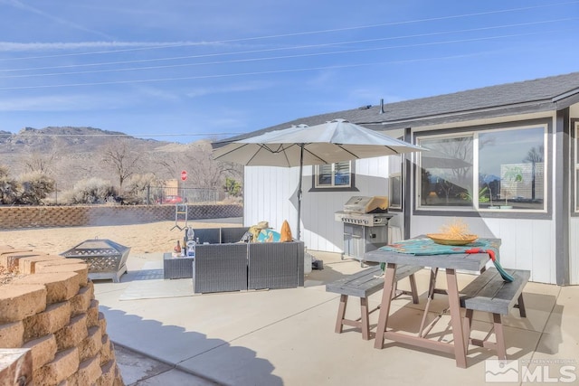 view of patio / terrace featuring grilling area, an outdoor living space with a fire pit, and a mountain view