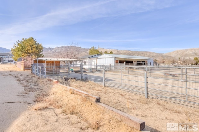 view of stable featuring a mountain view and a rural view