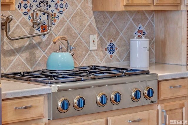 kitchen with light brown cabinetry and tasteful backsplash