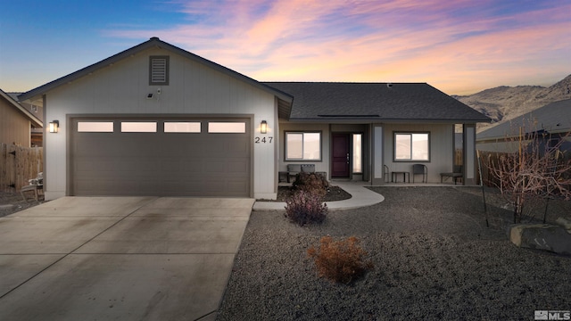 single story home featuring a mountain view, a garage, and covered porch