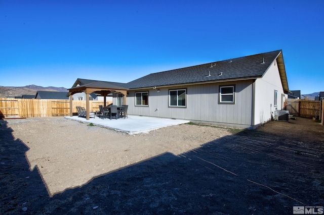 rear view of property with a patio area, a mountain view, and central AC unit