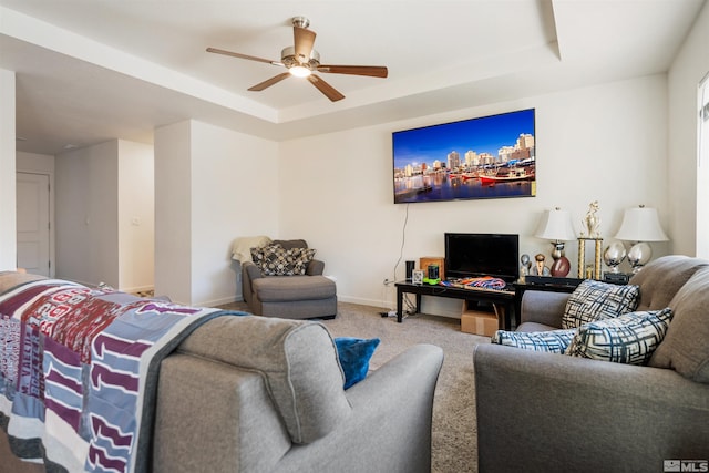 living room featuring ceiling fan, a raised ceiling, and carpet