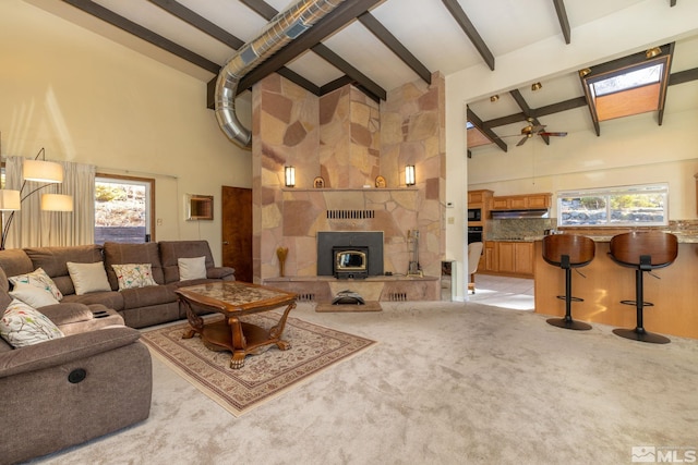 living room with light carpet, high vaulted ceiling, plenty of natural light, and a fireplace