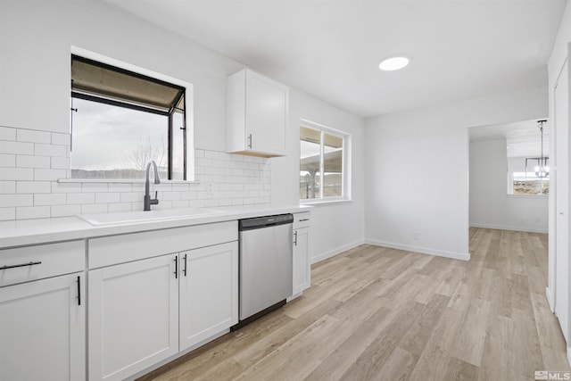 kitchen with light hardwood / wood-style flooring, sink, backsplash, dishwasher, and white cabinets