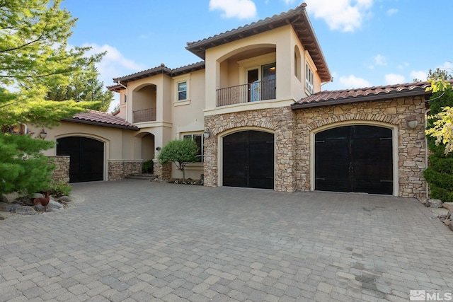 mediterranean / spanish-style home with a garage and a balcony