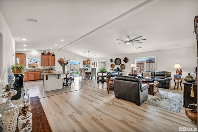 living room with light wood-type flooring, vaulted ceiling, and ceiling fan