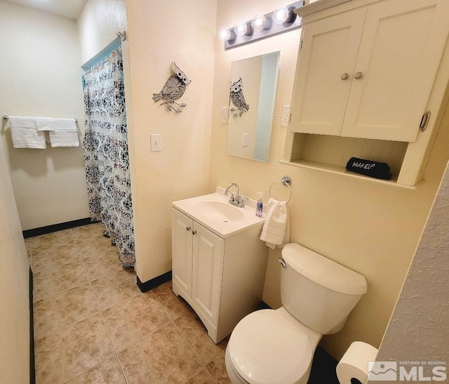 bathroom featuring toilet, tile patterned flooring, and vanity