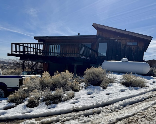 snow covered house featuring a deck