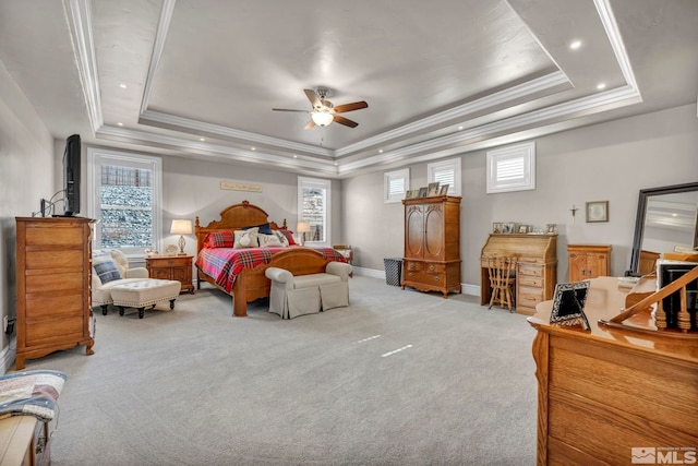 bedroom featuring light carpet, a tray ceiling, and ornamental molding